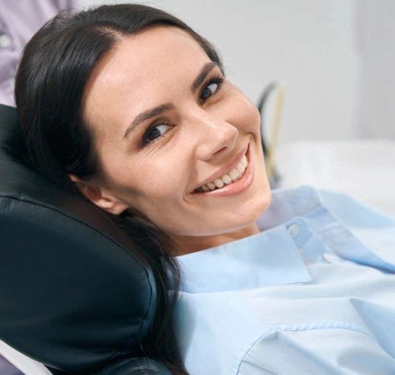 Happy patient smiling in dental chair at Bartlesville Dental Studio during appointment.