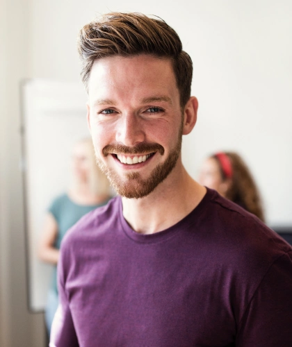 Smiling male dental professional in purple shirt at Bartlesville Dental Studio office setting.