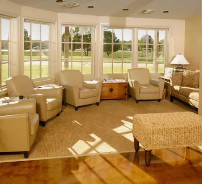 Bright waiting room at Bartlesville dental studio featuring comfortable seating and expansive windows overlooking green land.